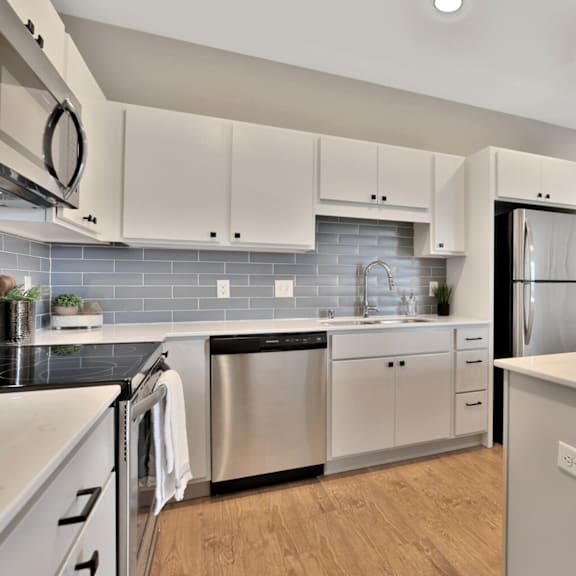 A modern kitchen with stainless steel appliances and white cabinets.