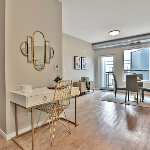 A room with a desk, chair, and mirror.