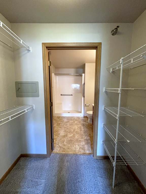 A hallway with a doorway leading to a bathroom and a wall-mounted security camera.