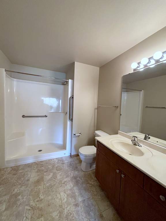 A bathroom with a toilet, sink, and shower.