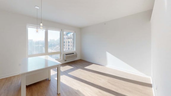 an empty living room with a large window and a table
