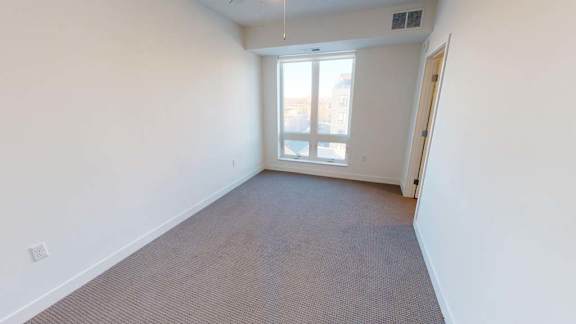 an empty room with a window and a door
