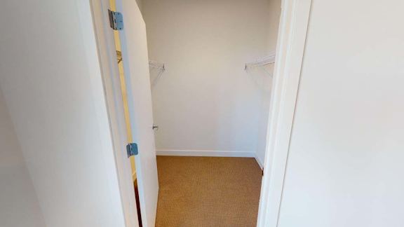 a white room with a closet and a white door