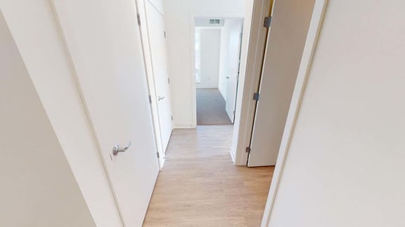 a hallway with white walls and a wood floor