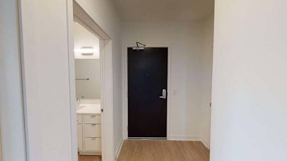 a hallway with a black door and a bathroom
