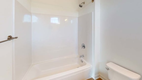 a white bathroom with a tub and a toilet