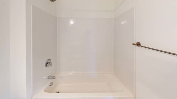 a white bathroom with a shower and a white tub