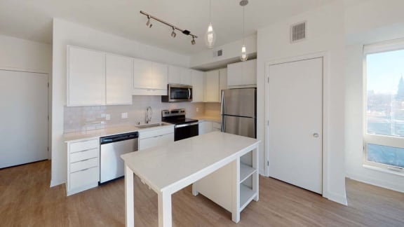 a white kitchen with a white table and a refrigerator
