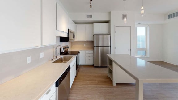 a large kitchen with a sink and a refrigerator