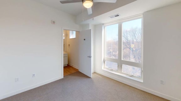 a living room with a large window and a door to a bathroom