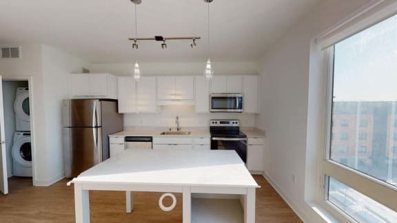 an empty kitchen with a white counter top