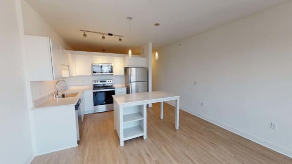 an empty kitchen with a white table and a sink