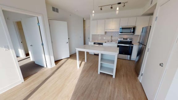 a kitchen with a white table and a refrigerator