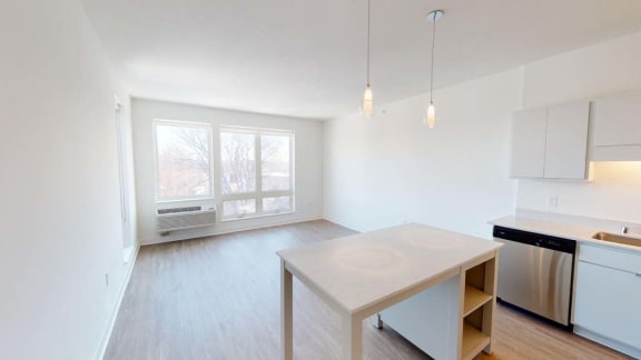 an empty kitchen with a white table and a window