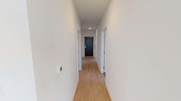 a hallway with a wood floor and white walls