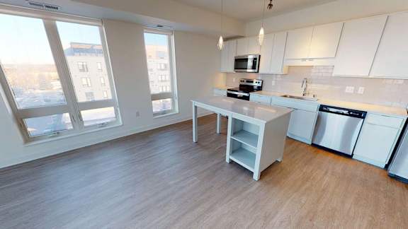 an empty kitchen with a large window and a table