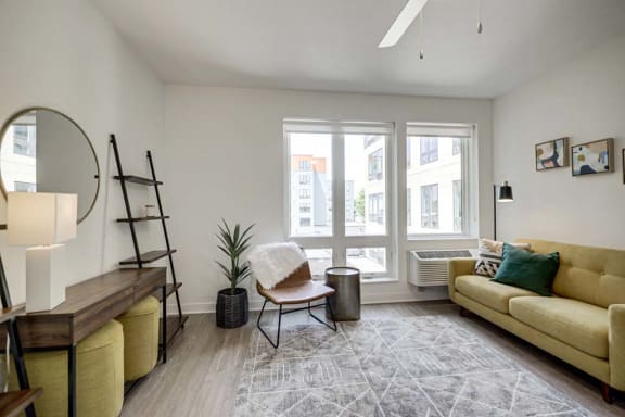 a living room with a couch and a chair and a window