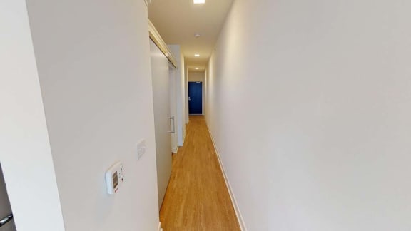 a long hallway with a wood floor and white walls