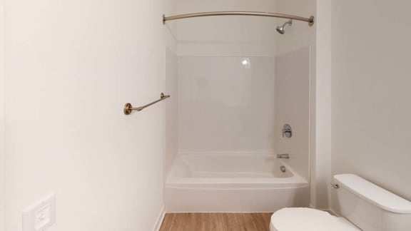 a white bathroom with a white toilet and a bath tub