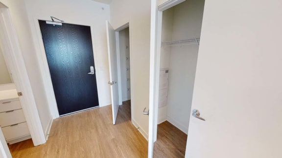a hallway with a black door and a closet