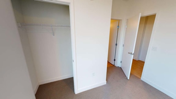 a bedroom with a closet and a door to a hallway