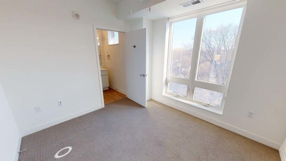 an empty room with a large window and a door