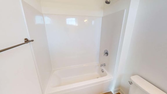 a white bathroom with a tub and a toilet