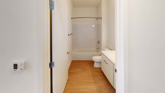 a white bathroom with a toilet and a shower
