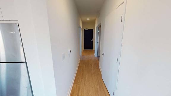 a hallway with white walls and a wooden floor