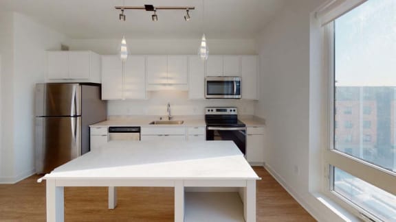 an empty kitchen with a large white table