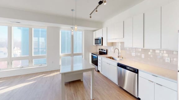 a large kitchen with white cabinets and stainless steel appliances