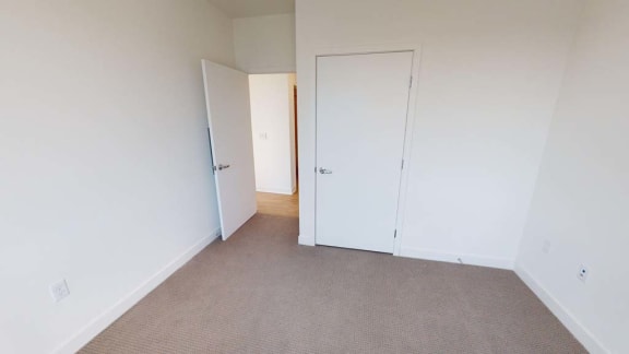 an empty room with a door to a closet