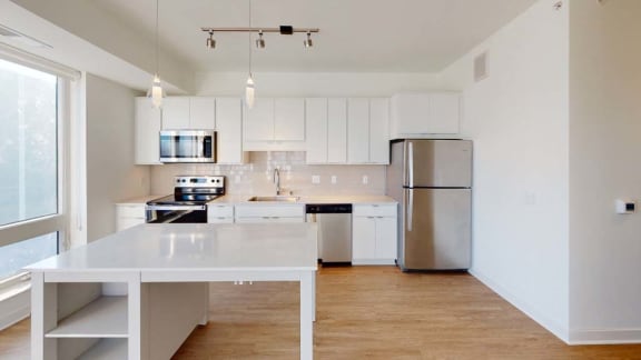 a kitchen with white cabinets and a stainless steel refrigerator