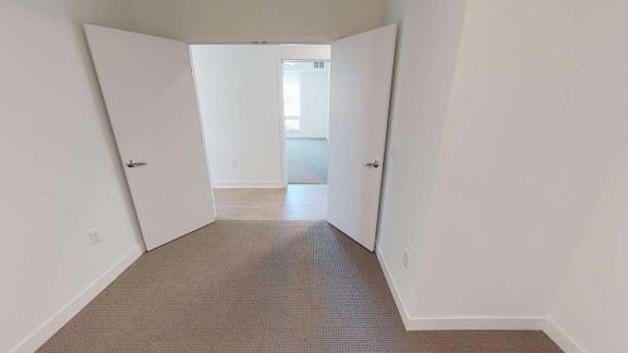 an empty room with white walls and a carpet