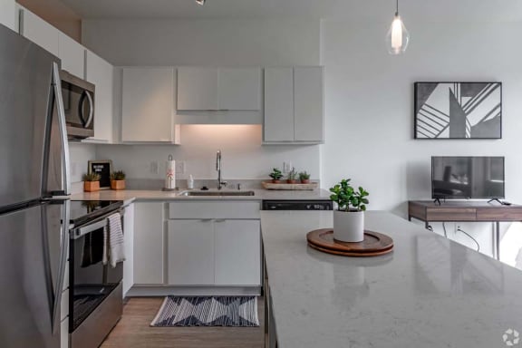 a white kitchen with a counter top and a refrigerator