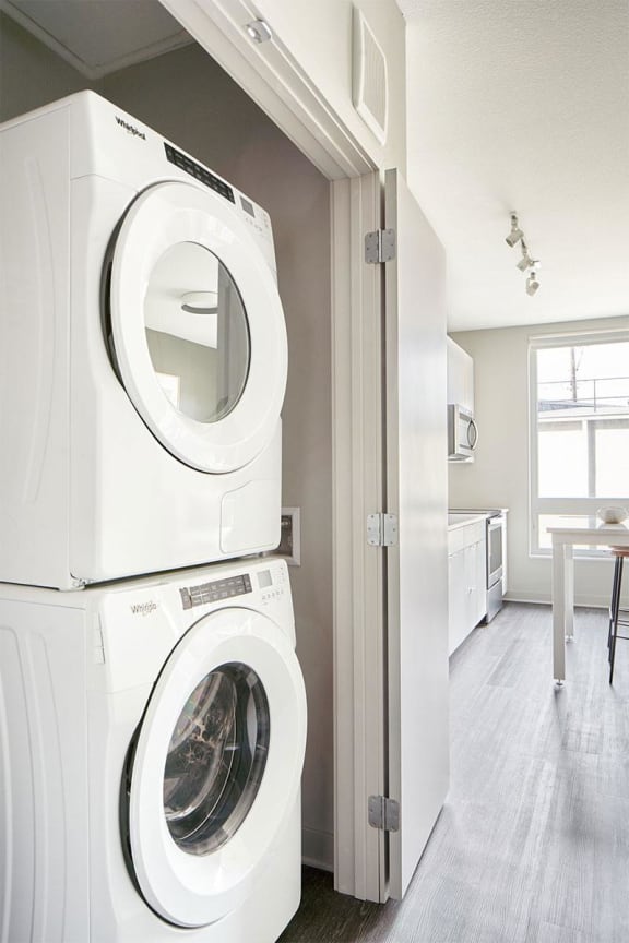 a white washer and dryer in a white laundry room