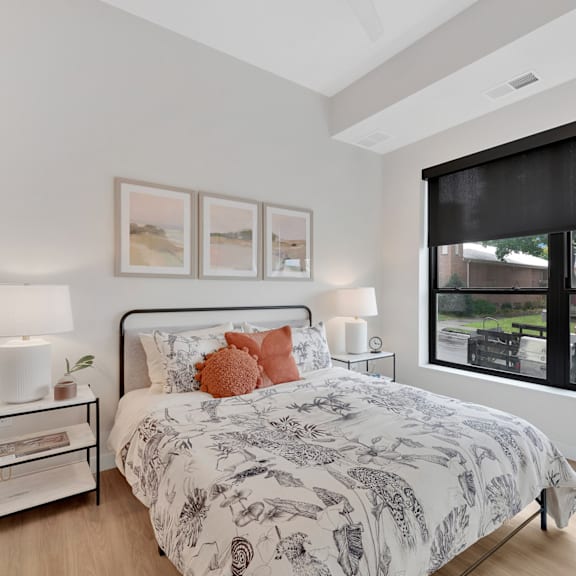 A bedroom with a large bed and a window with a view of a field.