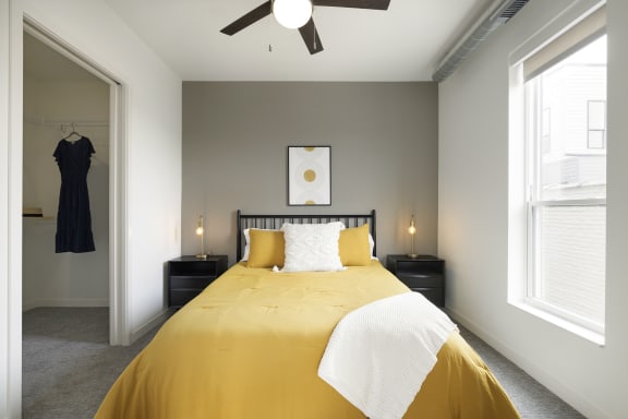 a bedroom with a yellow bed and a ceiling fan