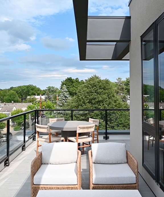 A balcony with two chairs and a table.