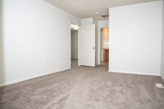 an empty living room with carpet and white walls