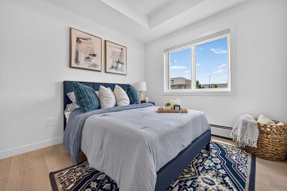 A bedroom with a large bed and two pictures on the wall.