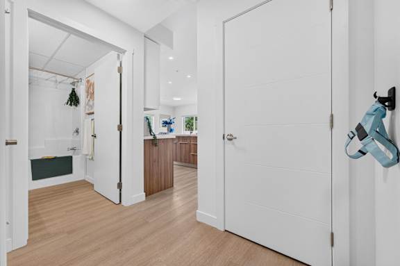 A white door is open to a kitchen.