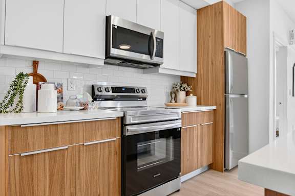 A modern kitchen with wooden cabinets and stainless steel appliances.