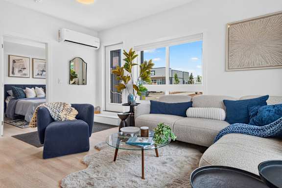 A living room with a blue chair and a grey couch.