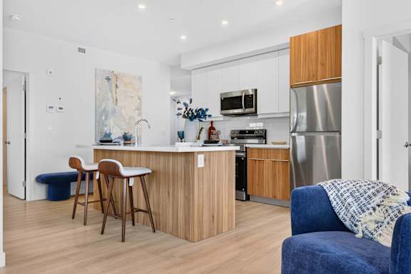 A kitchen with a blue chair and a wooden table.