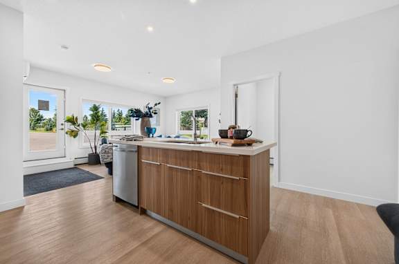 A kitchen with a white counter top and wooden cabinets.