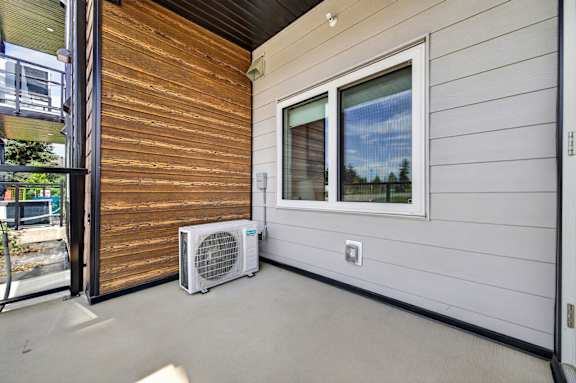 A patio with a window and a fan.