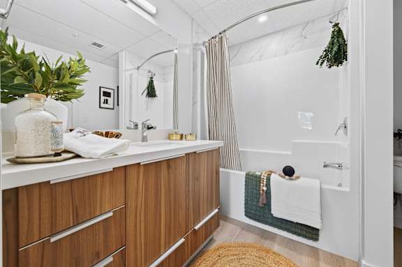A bathroom with a white countertop and wooden drawers.