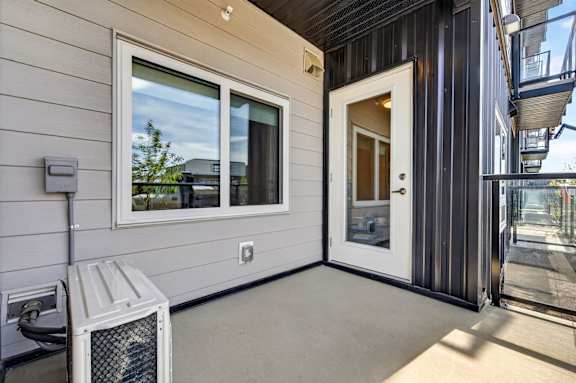 A white air conditioning unit sits on a patio.