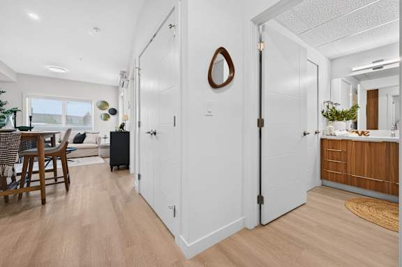 A white door with a mirror on the wall behind it.